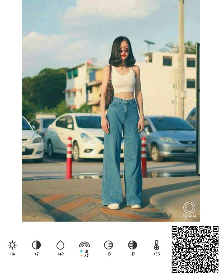 a woman standing in front of a parking lot wearing high waist jeans and cropped tank top