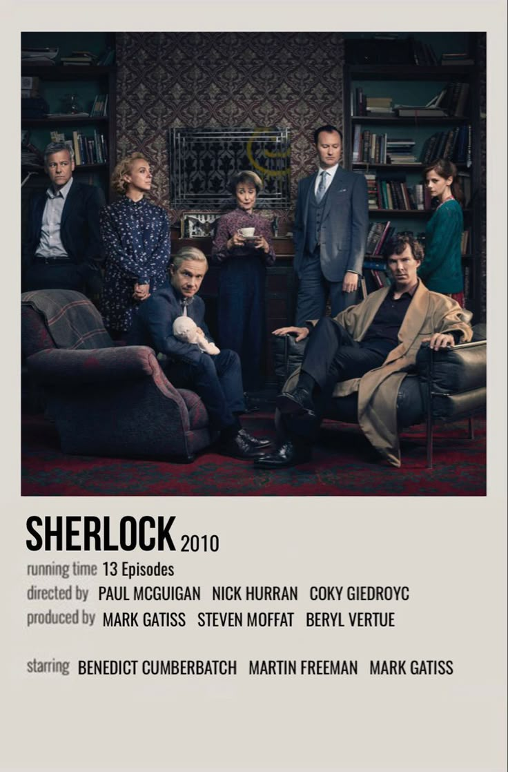 a group of people standing and sitting in front of a book shelf with books on it