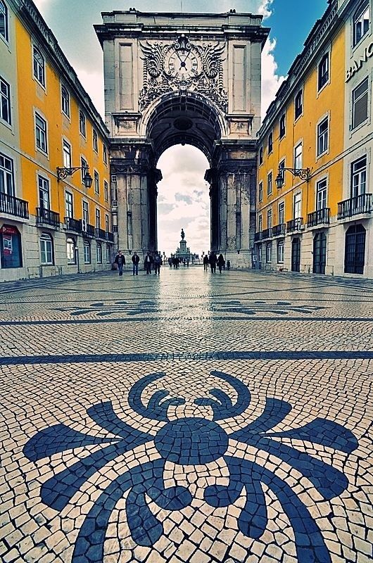 an arch in the middle of a cobblestone street