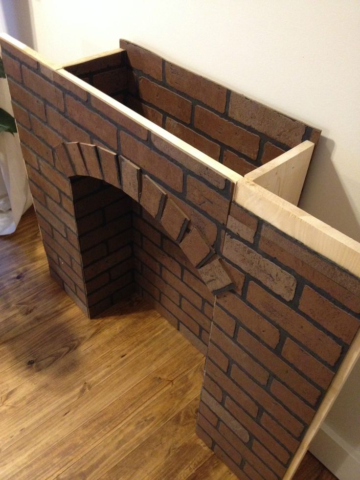 a brick oven built into the side of a wall in a room with hard wood flooring