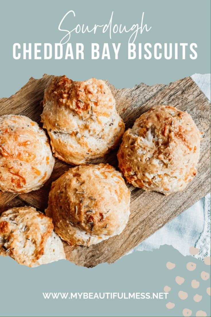 four cheddar bay biscuits on a wooden board with text overlay that reads sourdough cheddar bay biscuits