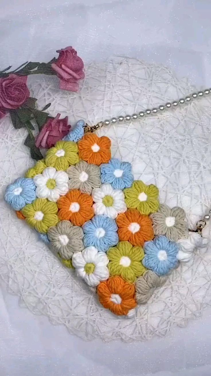 a purse with flowers on it sitting on a doily