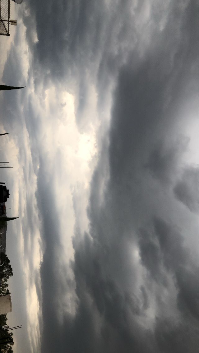 the sky is full of clouds and some buildings