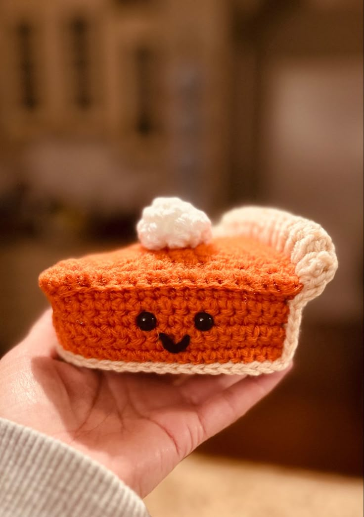 a small crocheted piece of food is held in someone's hand