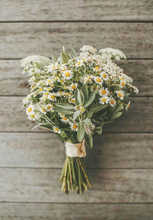 a bouquet of flowers sitting on top of a wooden table with text overlaying it