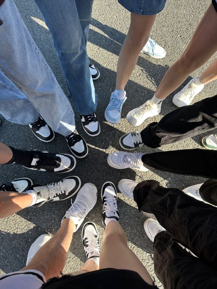 a group of people standing in a circle with their feet on each other's legs