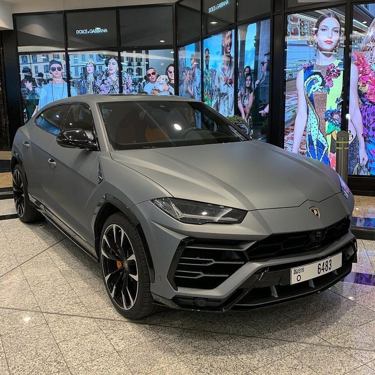 a grey sports car parked in front of a window display