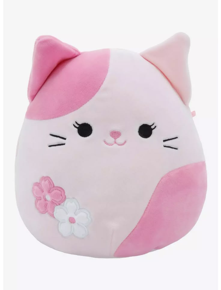 a pink and white cat stuffed animal with flowers on it's chest, sitting in front of a white background