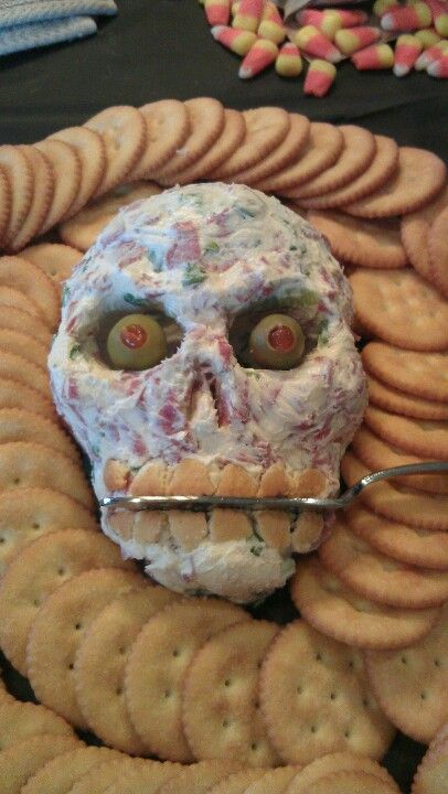 a fake skull made out of crackers on top of a pile of cookies with the caption skull cheeseball the ultimate collection of creepy, gross and ghoulish halloween recipes