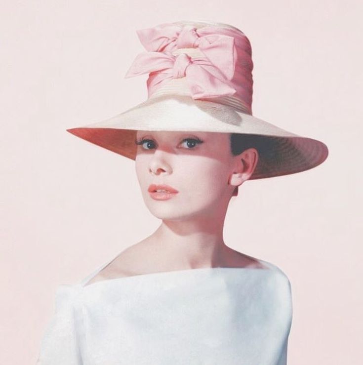 a woman wearing a white dress and pink hat