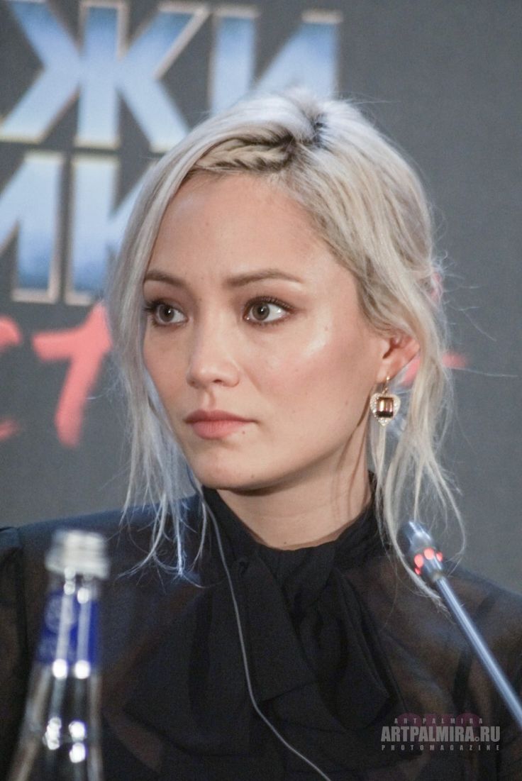 a woman with blonde hair sitting in front of a microphone