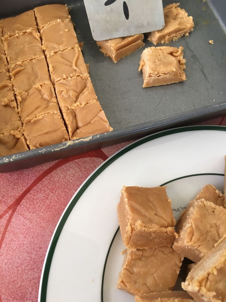 some brownies are sitting on a plate next to a pan with one cut in half