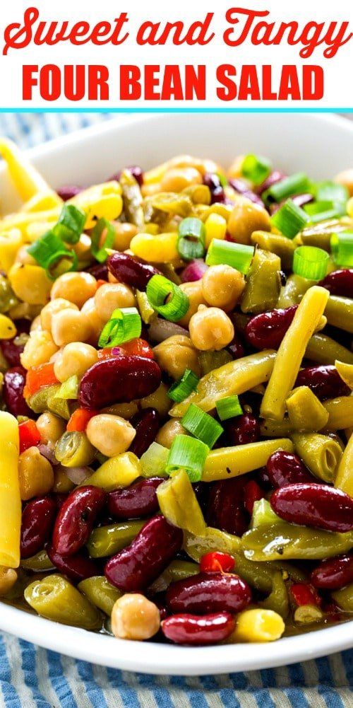 sweet and tangy bean salad in a white bowl on a blue striped tablecloth