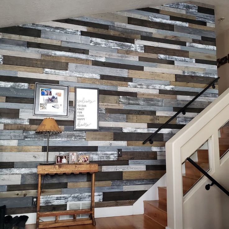 a wooden wall in a house with stairs and pictures hanging on the wall behind it