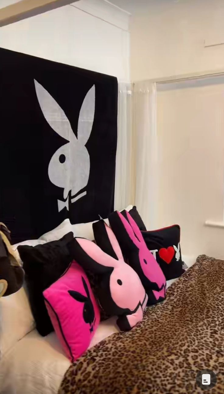 a bed with several pillows on top of it and an animal print blanket over the headboard