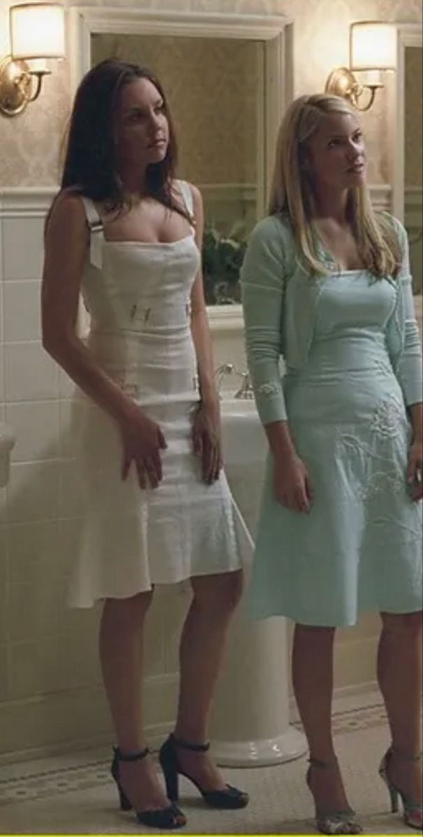 two women standing in front of a bathtub with their hands on their hipss