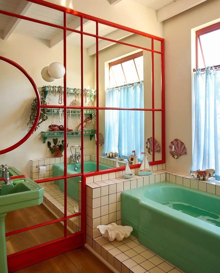 a bathroom with red and green accents in the bathtub, sink, and mirror