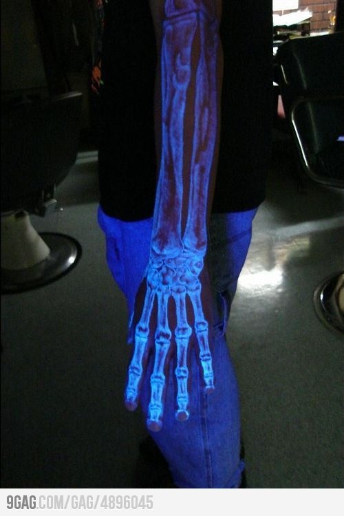 a man is holding his arm with glowing bones on it