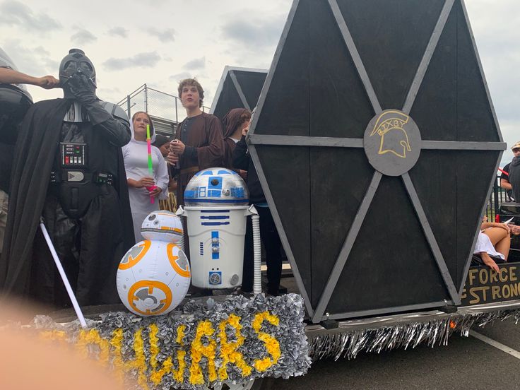 some people are standing in the back of a truck with star wars decorations on it