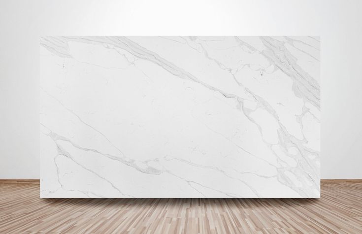 a white marble block sitting on top of a wooden floor in an empty room with wood floors