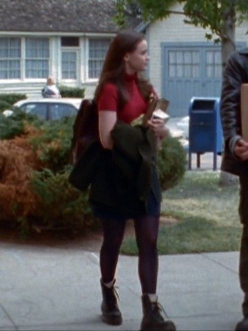 two people standing on the sidewalk talking to each other and holding boxes in their hands