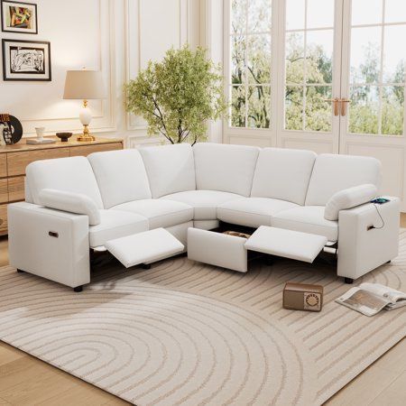 a living room with a white sectional couch and matching footstools on the rug