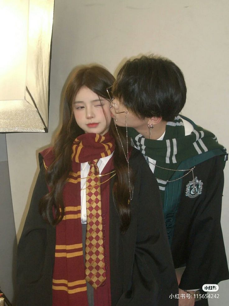 two people standing next to each other wearing harry potter scarves and scarfs on their heads