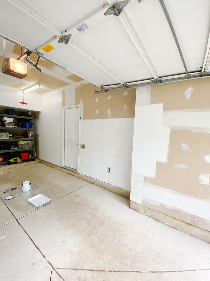 an empty garage with paint on the walls and tools in the floor next to it