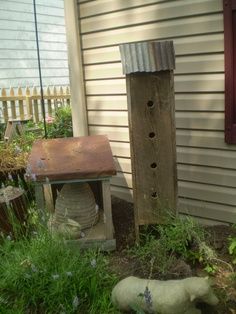 an old bird house is next to a wooden feeder