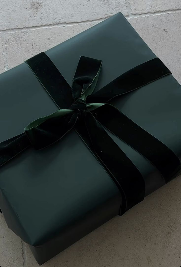 a large green present wrapped in black ribbon