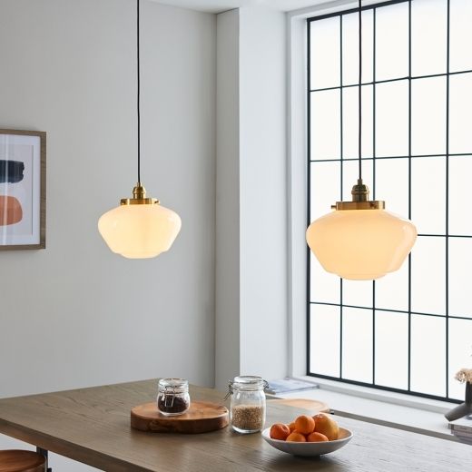 two lights hanging from the ceiling above a table with fruit on it and other items