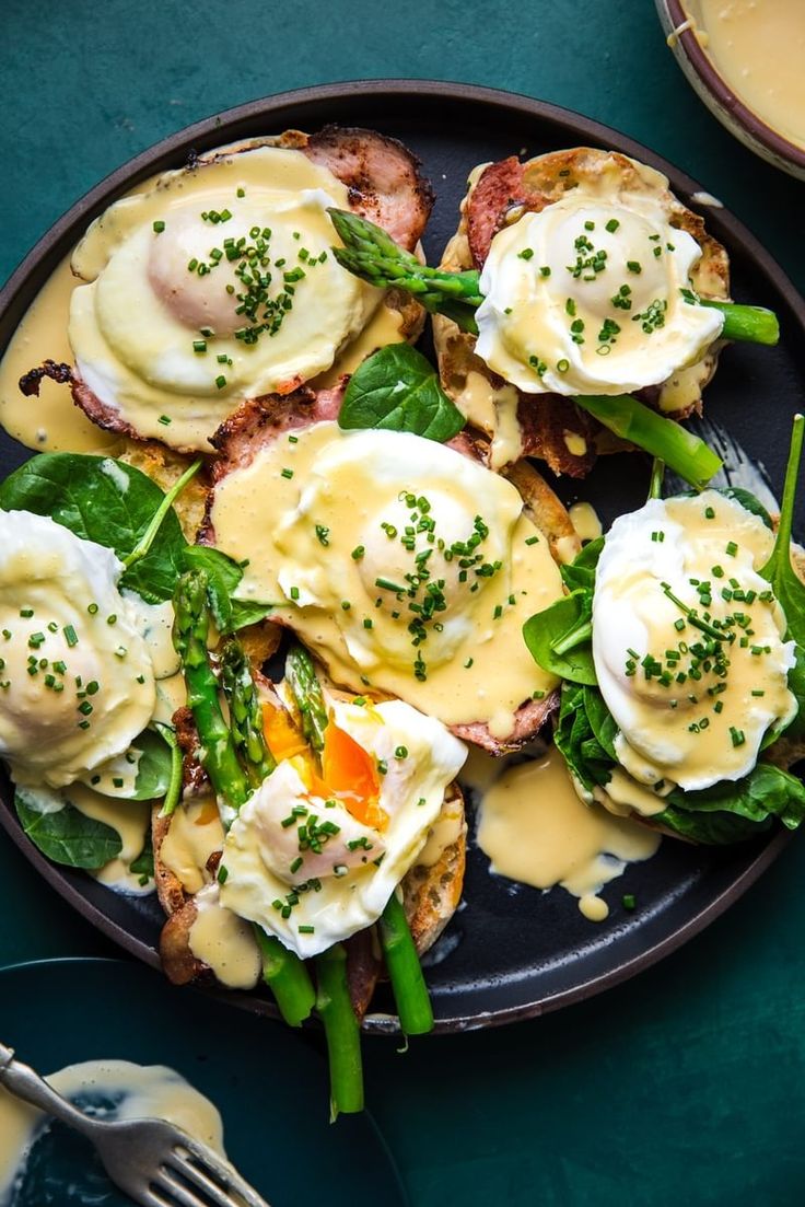 a black plate topped with eggs and green beans