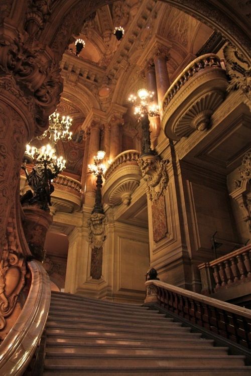 an ornate staircase with chandeliers in a building