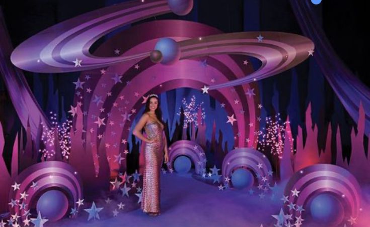 a woman standing on top of a stage surrounded by stars