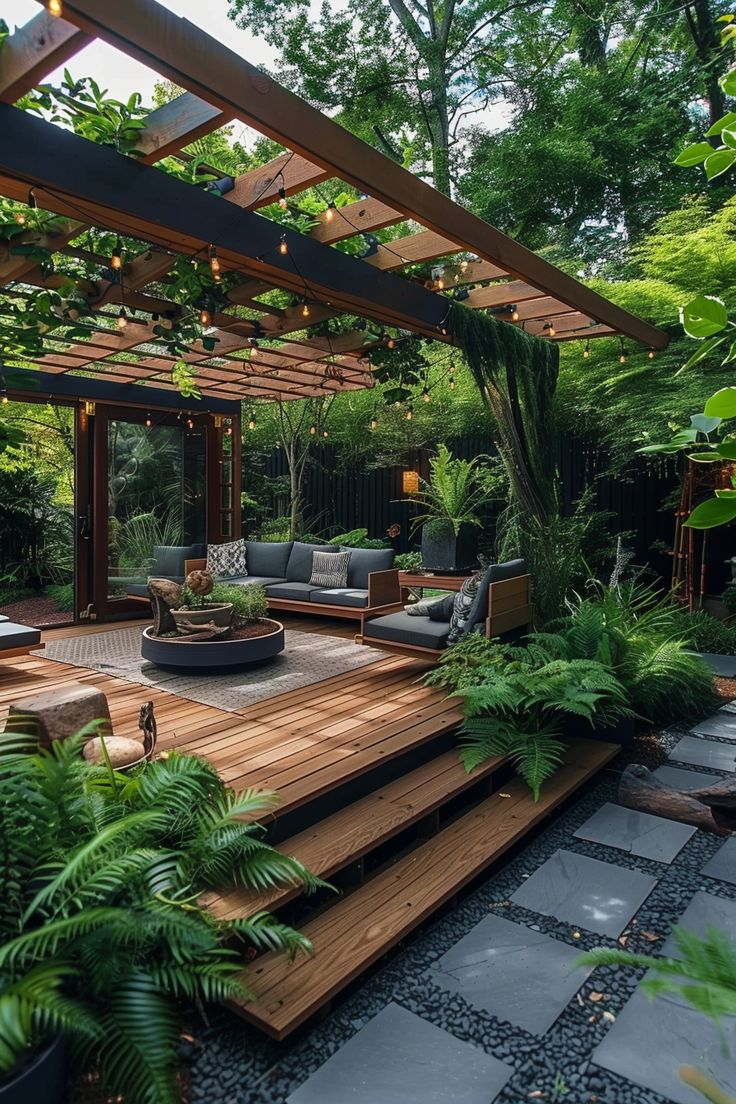 an outdoor living area with wooden decking and lots of greenery on the ground