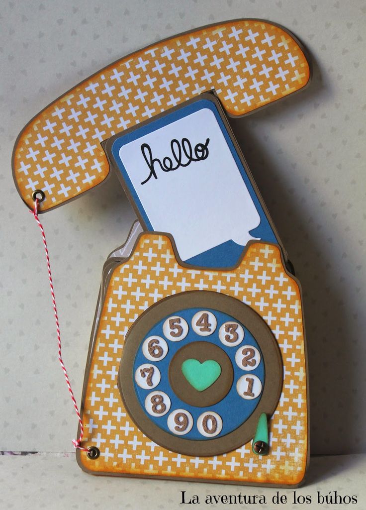 an orange and blue phone with a name tag attached to the front, hanging on a wall