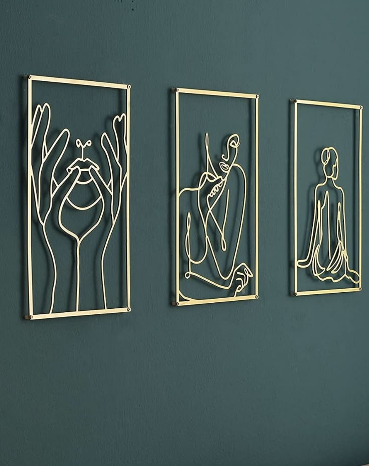 three metal artwork pieces hanging on the wall above a bed in a room with green walls