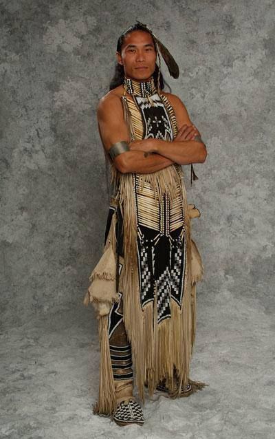 a native american man standing with his arms crossed