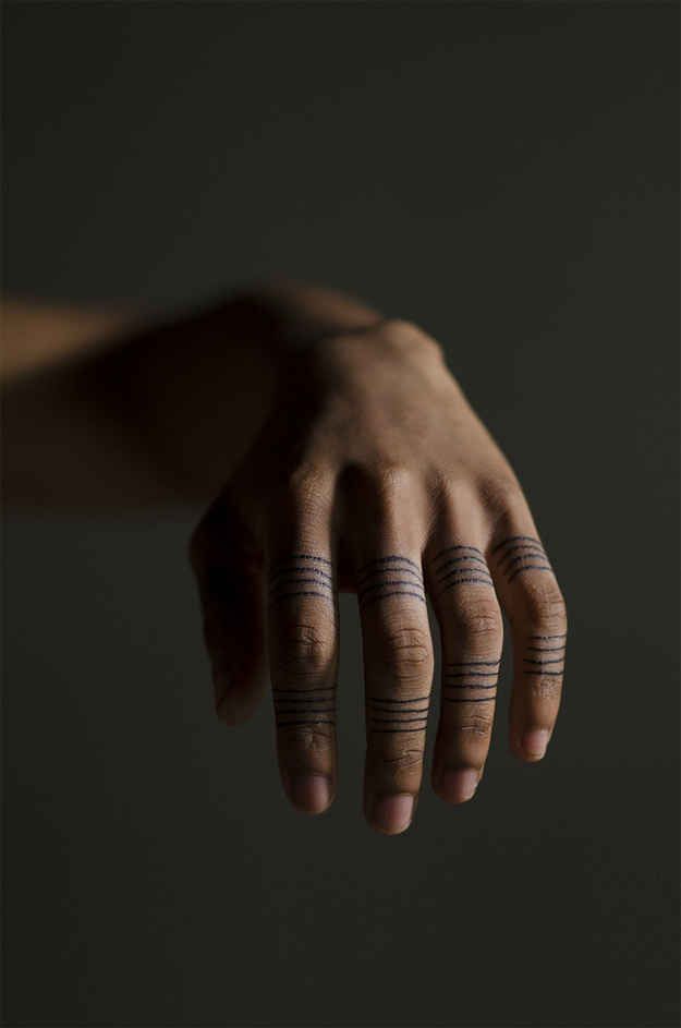 a hand with two small tattoos on it's fingers and the words cremebydesign written in cursive ink