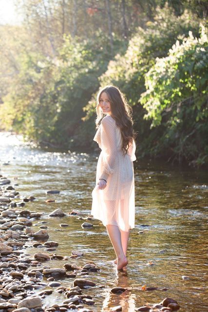 a woman standing on rocks in the water