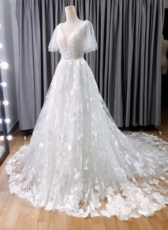 a white wedding dress on display in front of a mirror