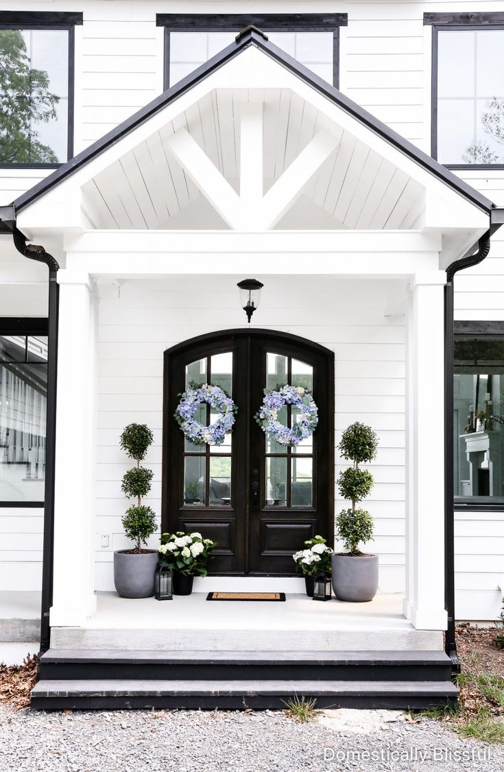 a white house with black trim and double doors