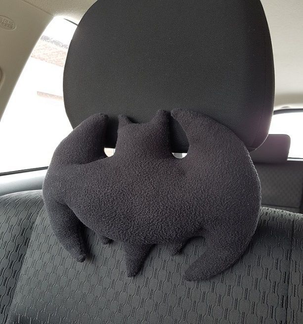 a stuffed animal is sitting in the back seat of a car with its eyes closed