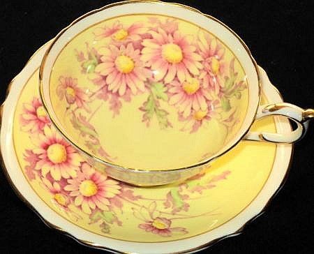 an antique tea cup and saucer decorated with pink daisies