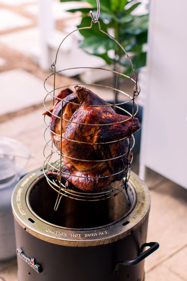 a roasting turkey is sitting on top of a grill with wire around it's sides