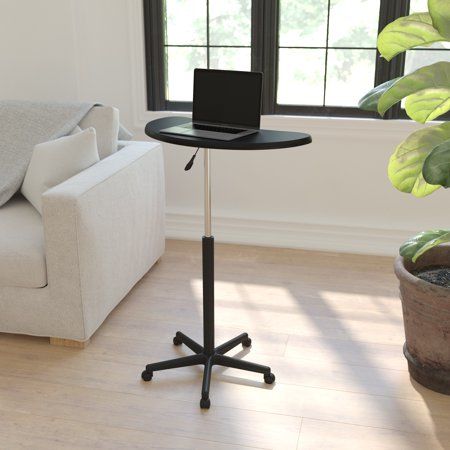 a laptop computer sitting on top of a wooden table next to a white couch in a living room