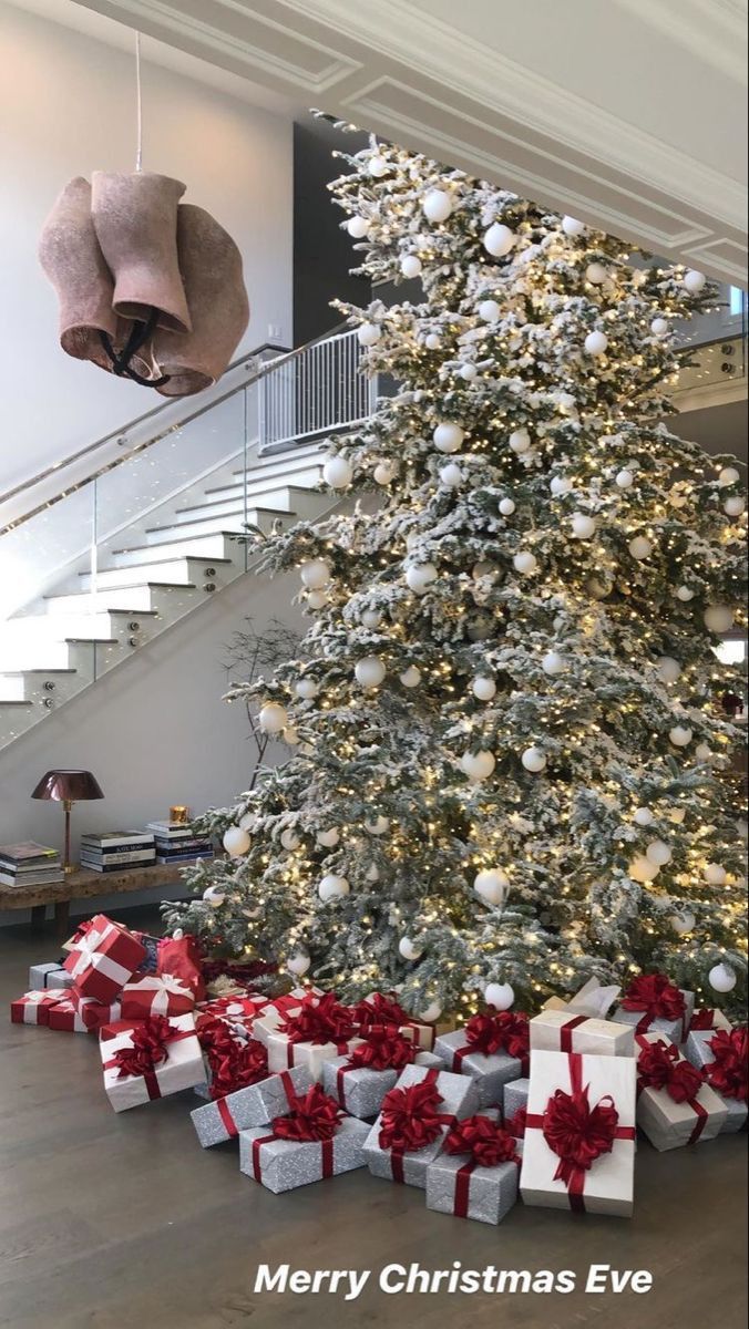 a large christmas tree with presents under it