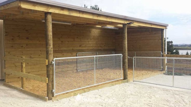 a small wooden building with a metal fence around it