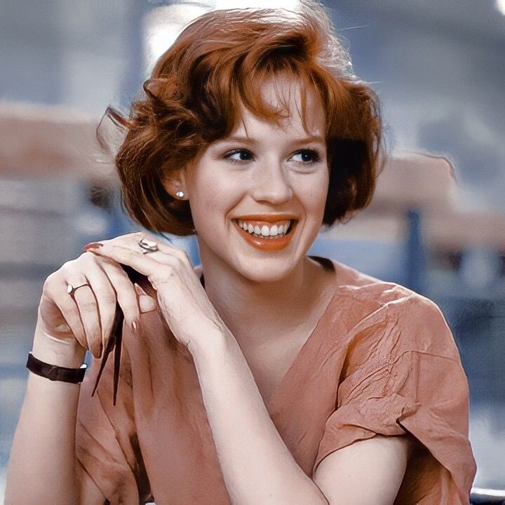 a woman sitting at a table smiling for the camera