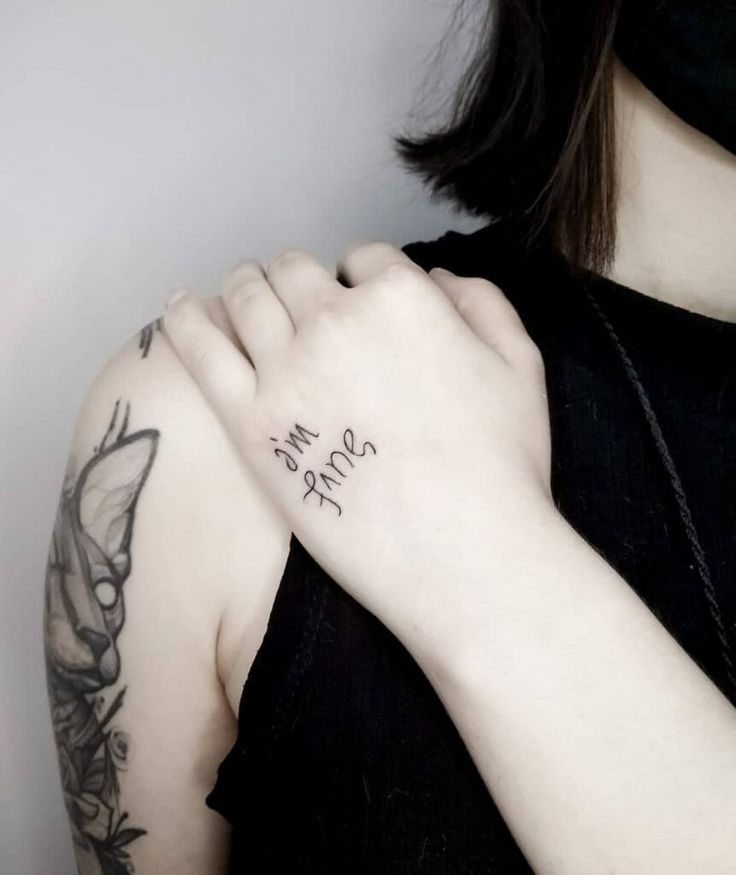 a woman with a tattoo on her arm and the word love is written in cursive writing